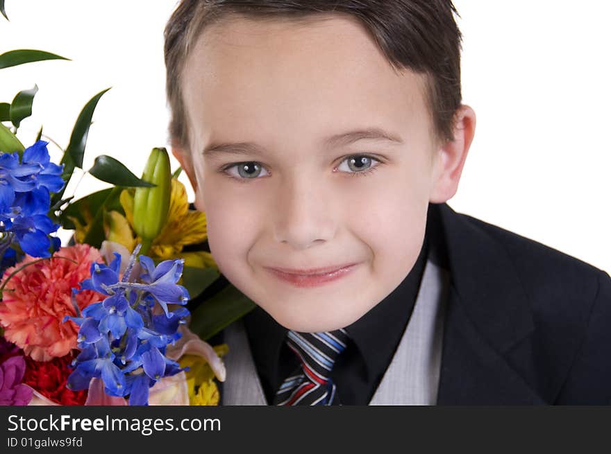 Image of small boy dressed in suit presenting flowers as a gift. Image of small boy dressed in suit presenting flowers as a gift