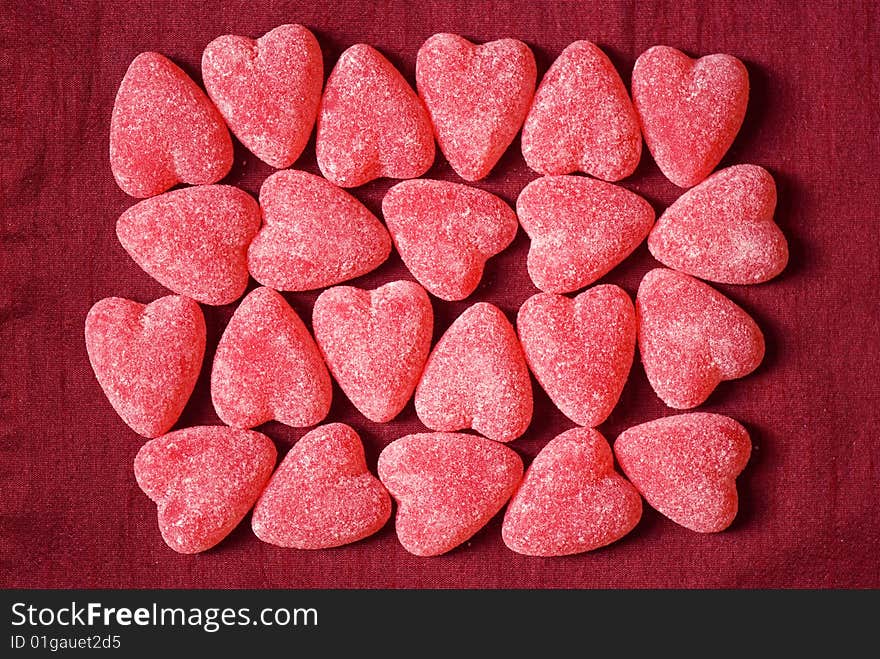 Red sugar hearts over fabric background