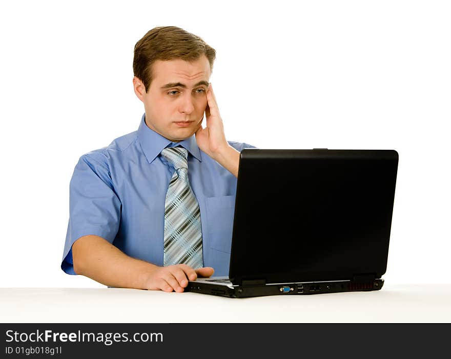 Tired man working on a laptop. Isolated on white.