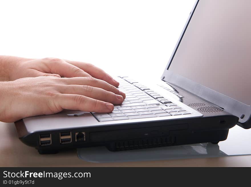 Two hands typing on a laptop Computer on a table with white background. Two hands typing on a laptop Computer on a table with white background.