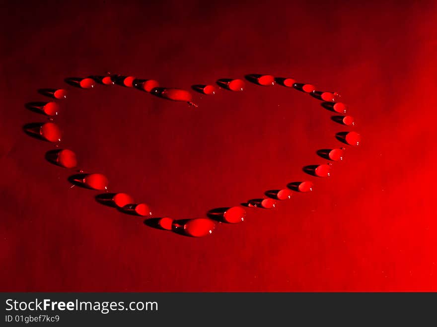 Water drops in the form of heart on a celebratory background