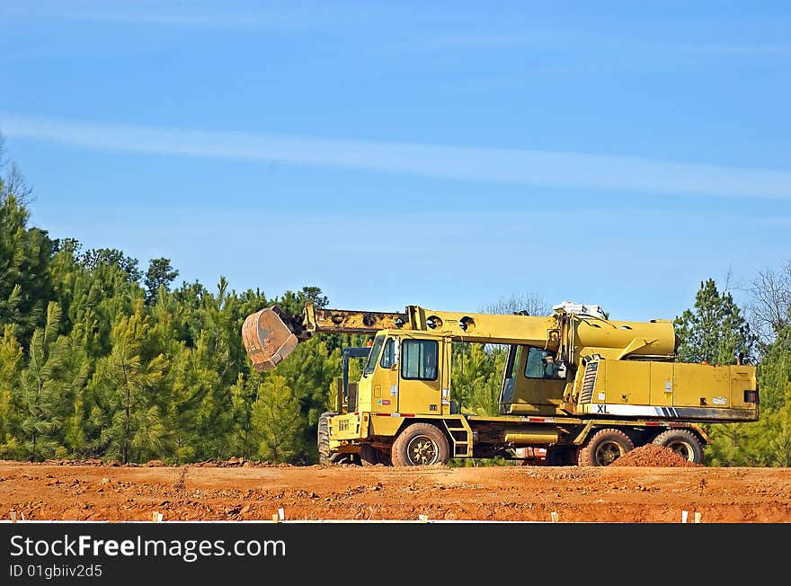 Yellow construction machinery against blue sky.