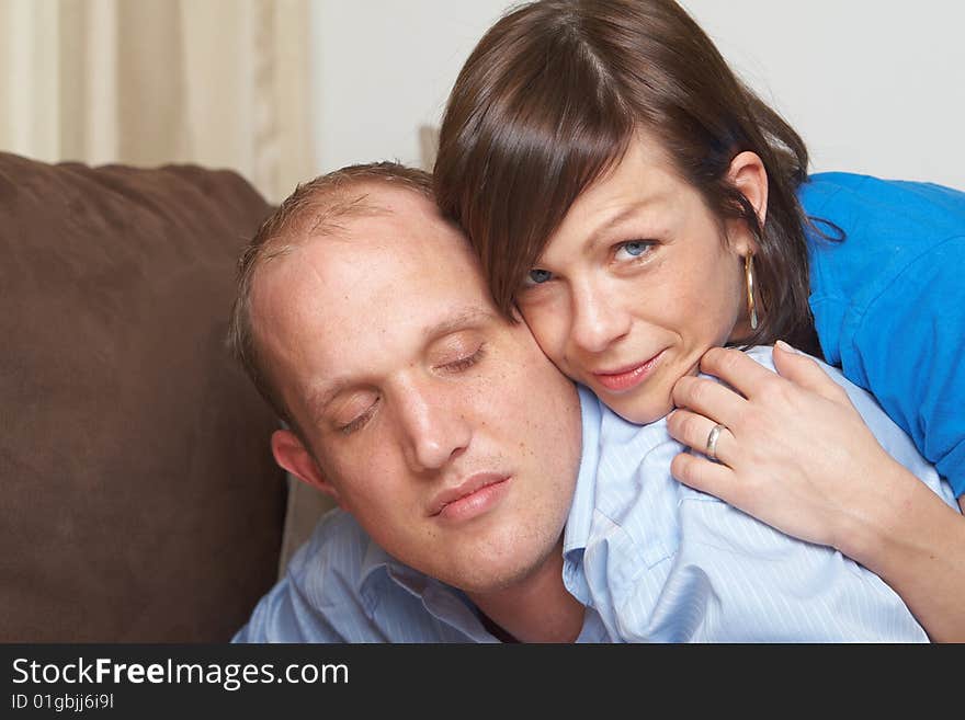 Beautiful young couple on a couch in their new appartment. The young man cloeses his eyes in comfort!