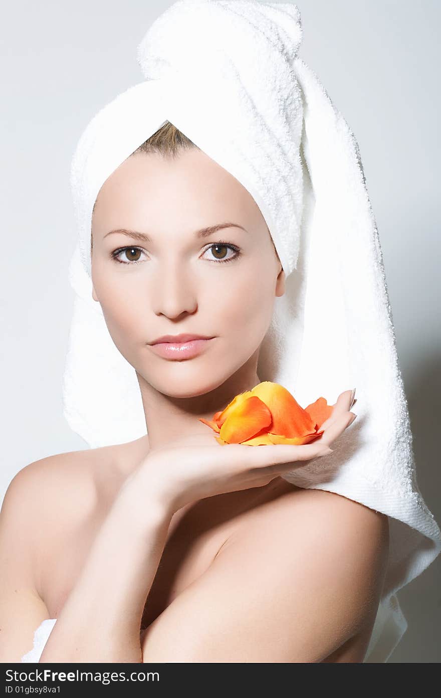 Closeup of young girl with a towel on her head.
She holds petals of roses in the hand. Closeup of young girl with a towel on her head.
She holds petals of roses in the hand.