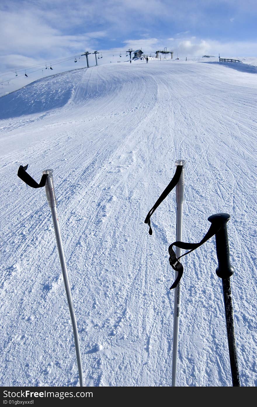 Three ski sticks with lift in the background