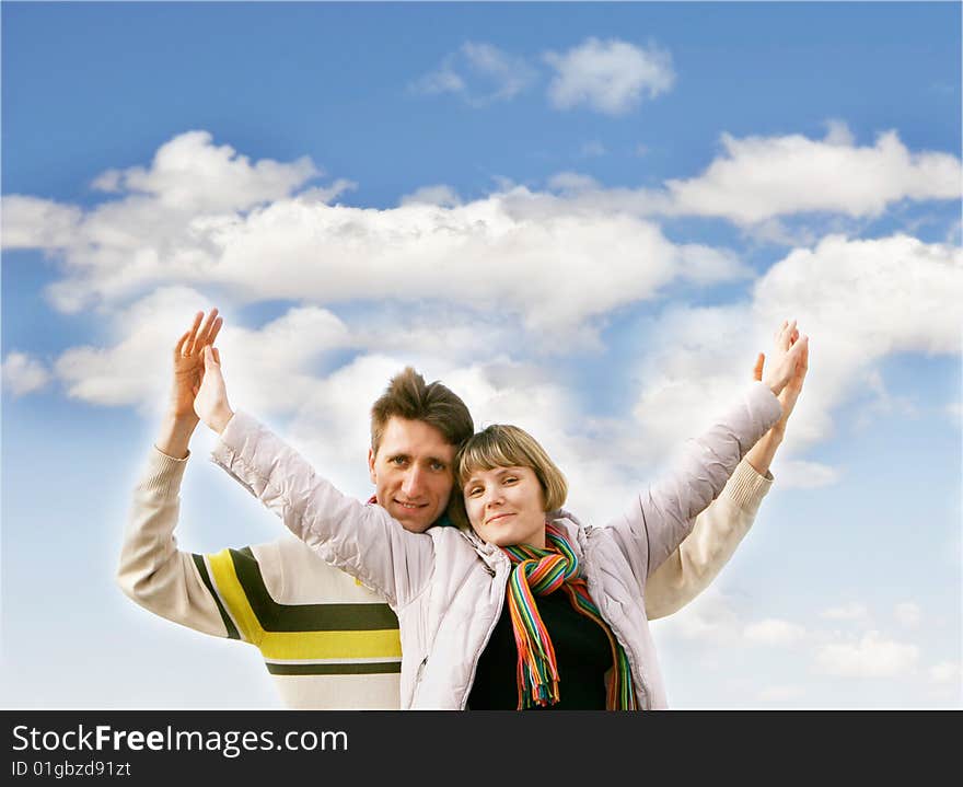 Young happy couple over sky background