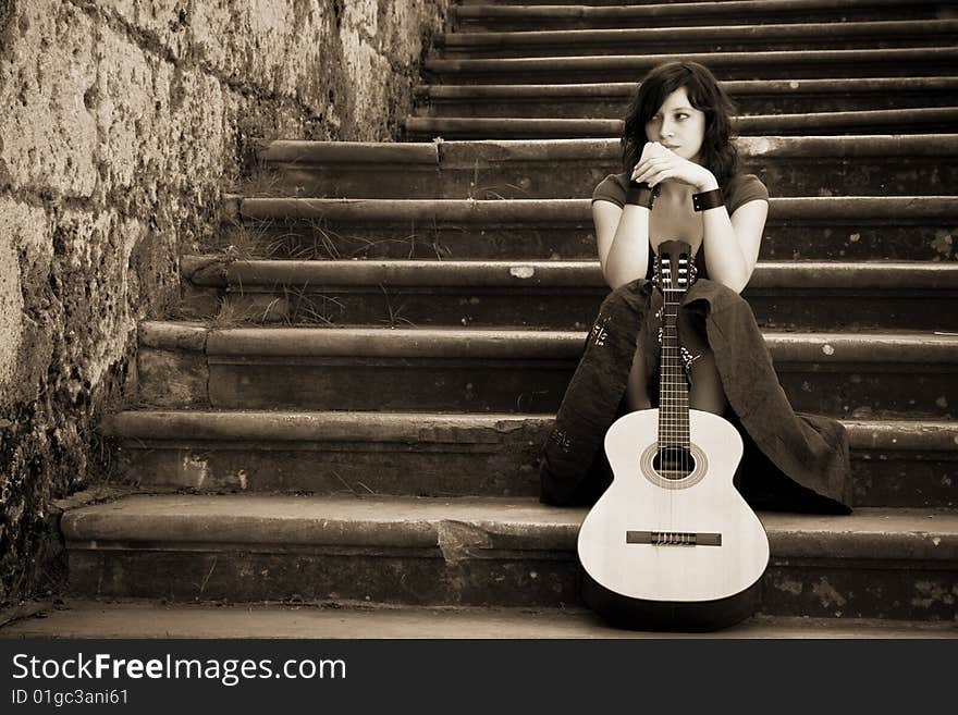 Young beautiful music performer caressing her guitar. Young beautiful music performer caressing her guitar