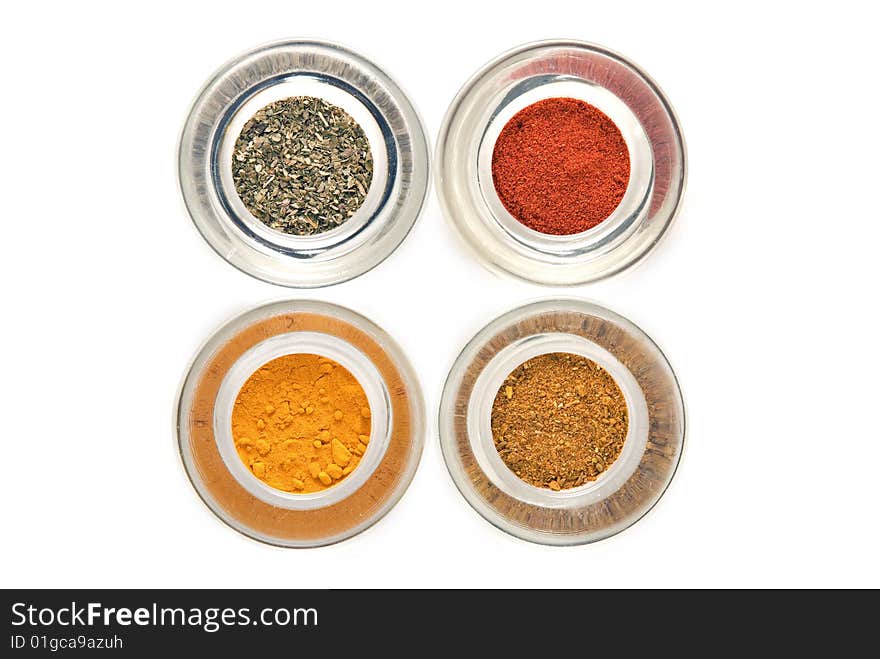 Four colorful spices in glass containers isolated on white background. Four colorful spices in glass containers isolated on white background