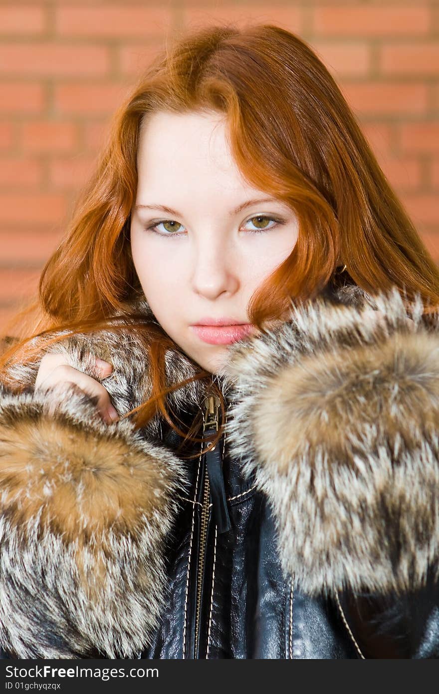 Beautiful red hair girl near a brick wall. Beautiful red hair girl near a brick wall