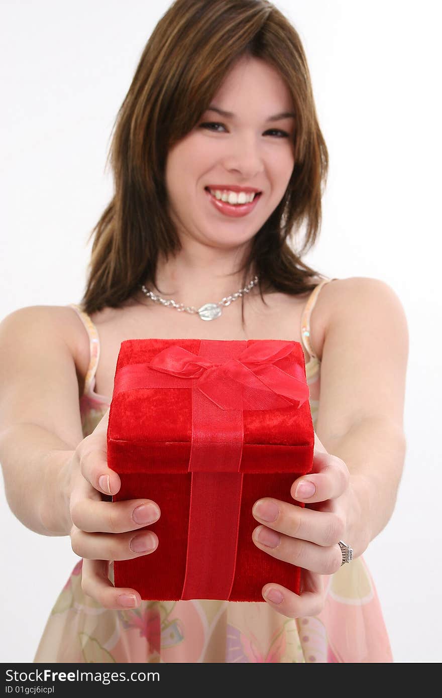 Beautiful 18 year old hispanic woman handing red gift box.  Focus on box. Beautiful 18 year old hispanic woman handing red gift box.  Focus on box.