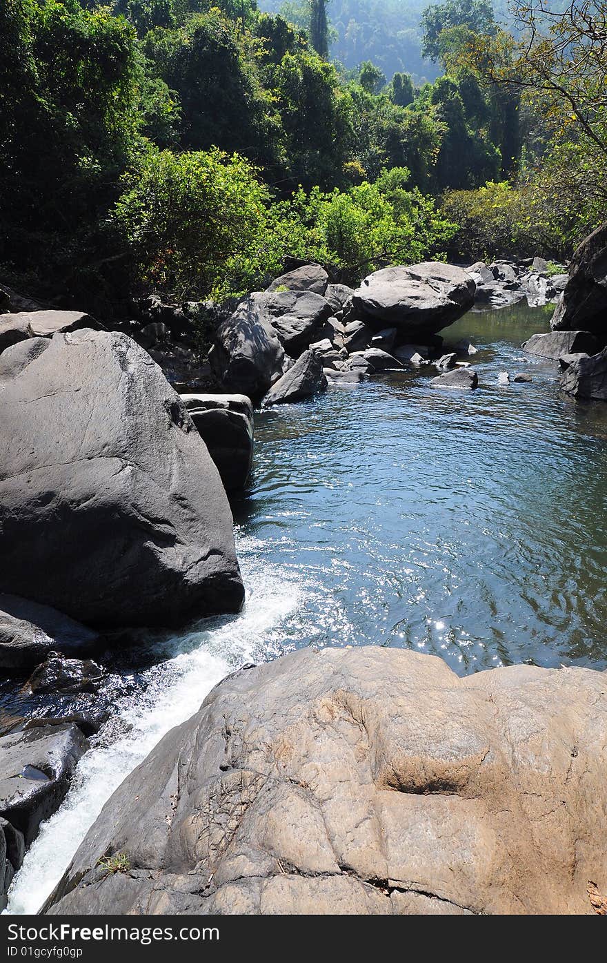 Lake and waterfall in mountains among huge stones and jungle forest. Lake and waterfall in mountains among huge stones and jungle forest