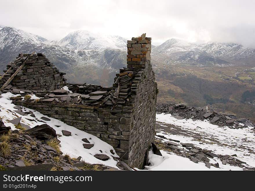 Abandoned buildings in a disused slate quarry in North Wales with a rugged mountain background. Abandoned buildings in a disused slate quarry in North Wales with a rugged mountain background.