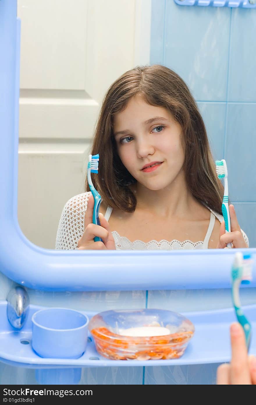 Teen girl to decide between the two toothbrushes