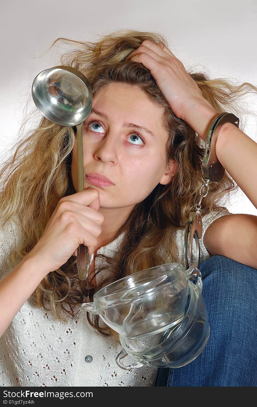 Young exhausted woman chained to pots with handcuffs. Young exhausted woman chained to pots with handcuffs