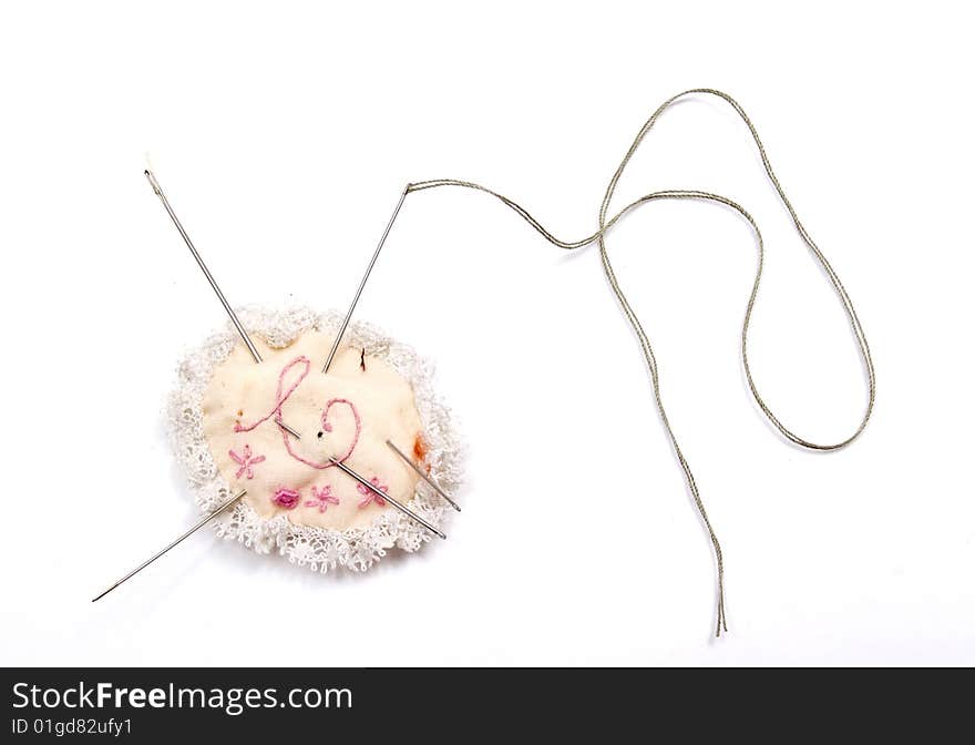 Sewing needle and thread,	
isolated on a white background