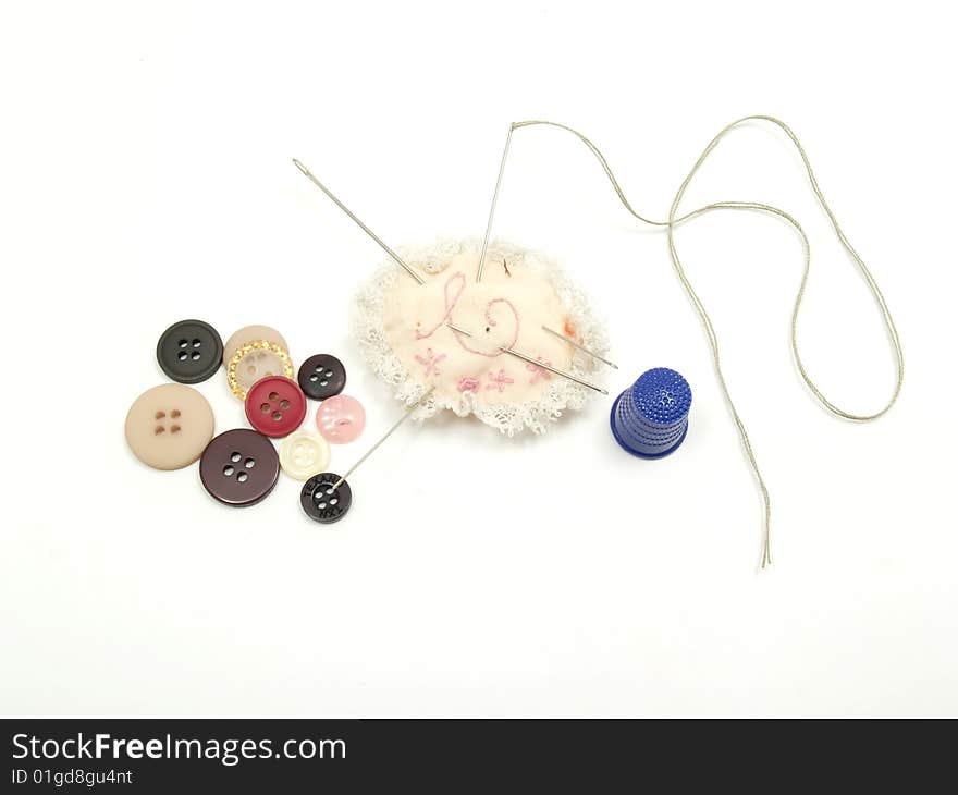 Needle and thread sewing buttons,	
isolated on a white background