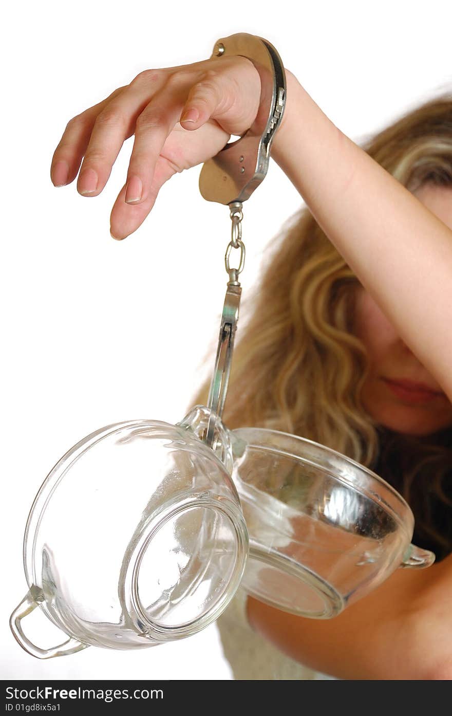 Young exhausted woman chained to pots with handcuffs. Young exhausted woman chained to pots with handcuffs