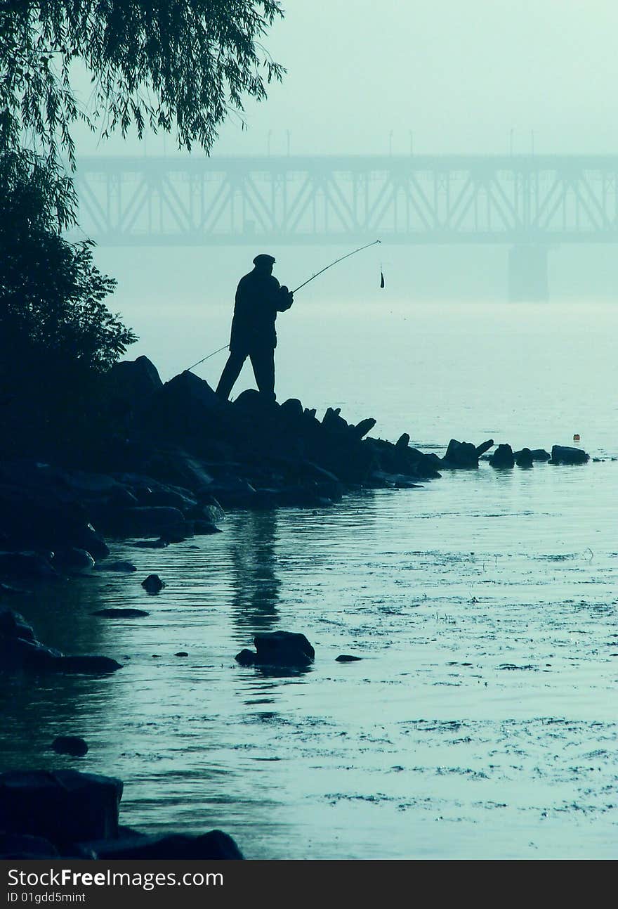 Silhouette of alone fisher near sunset river. Silhouette of alone fisher near sunset river