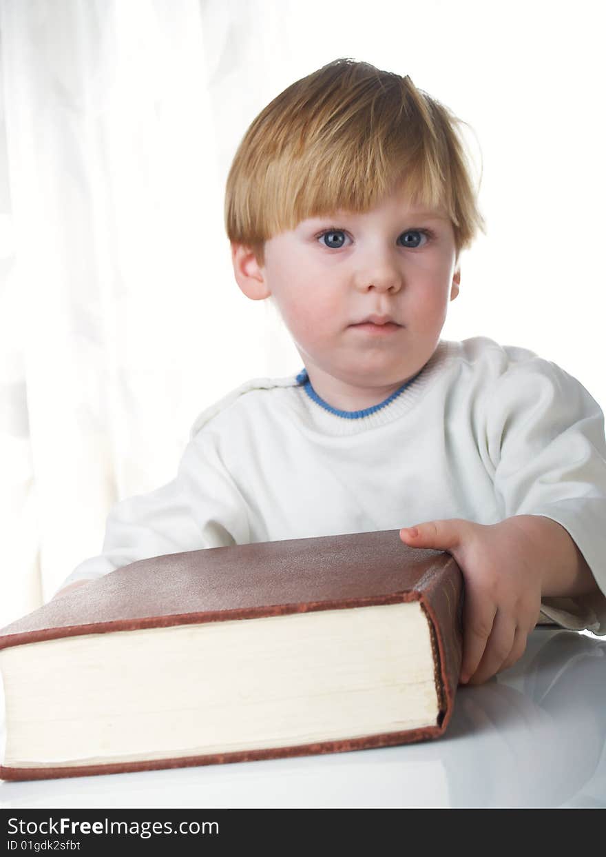 The boy with the big book in hands. The boy with the big book in hands