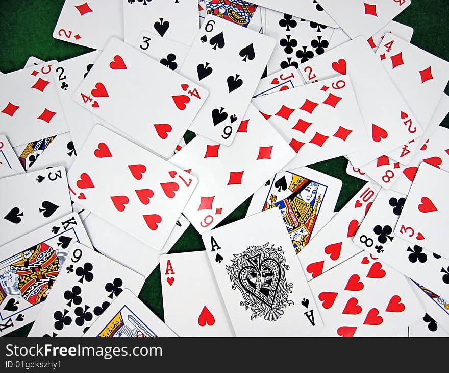 Playing cards randomly scattered on a green velvet table. Playing cards randomly scattered on a green velvet table.