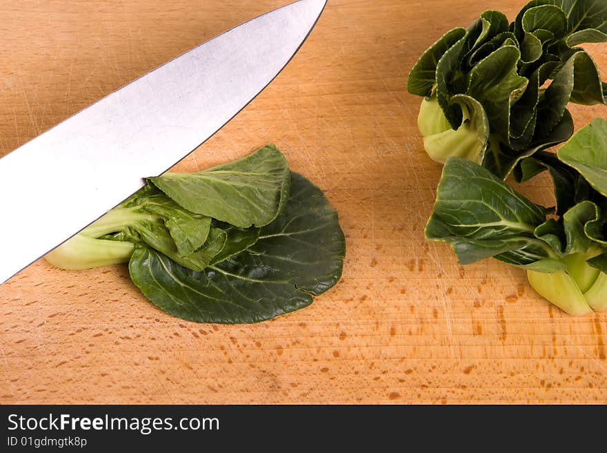 Cutting a bokchoy cabbage on a cutting board. Cutting a bokchoy cabbage on a cutting board