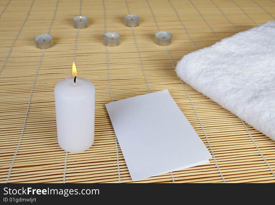 Spa objects. Candles, towel and paper.