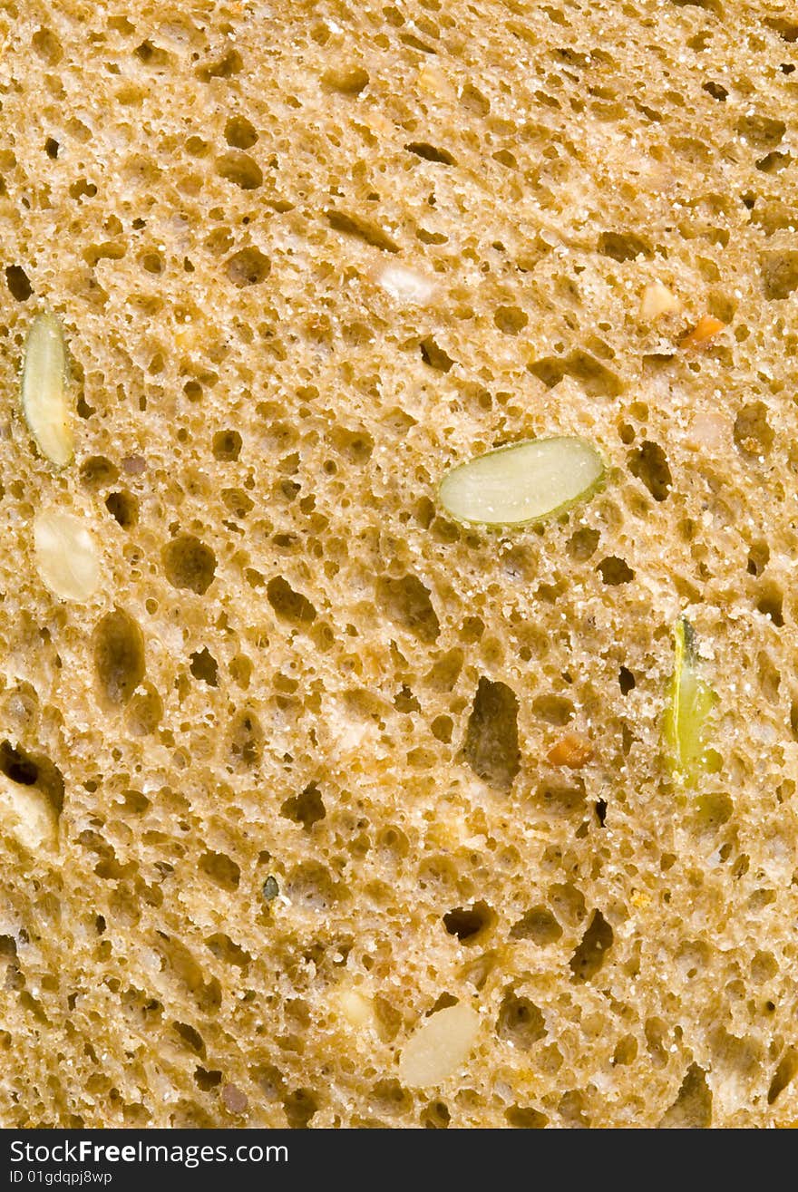 A close up of the texture of a slice of brown bread. A close up of the texture of a slice of brown bread