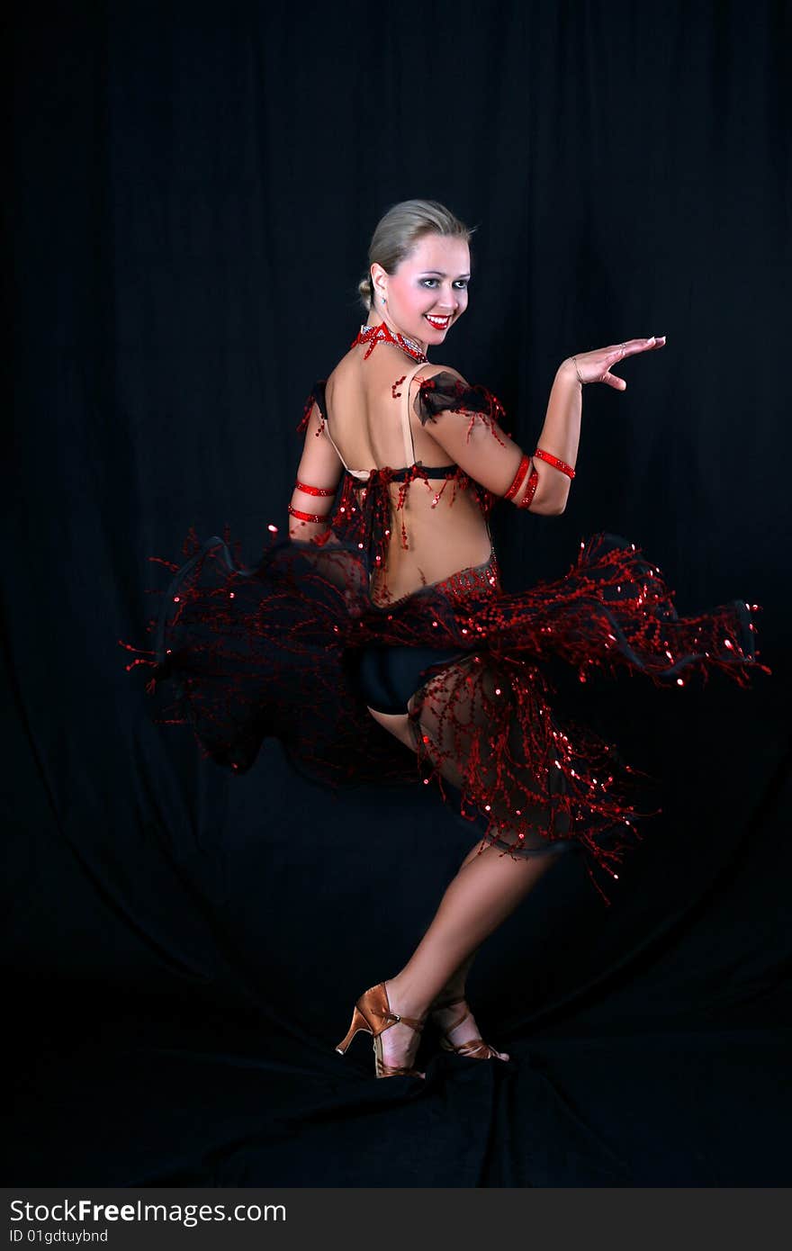 Lovely blonde latin dancer against black background