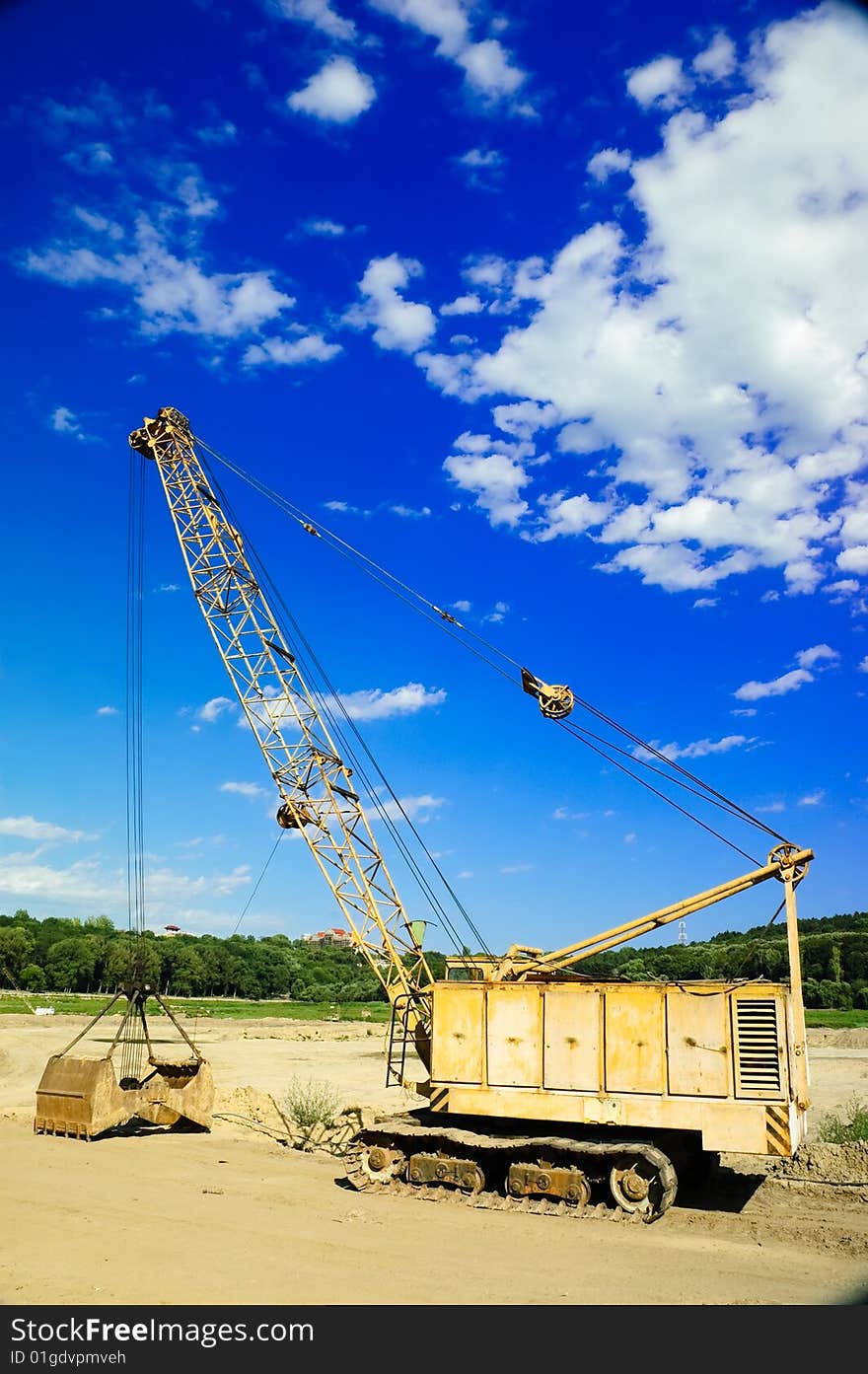 Yellow digger on the clay bottom of former lake