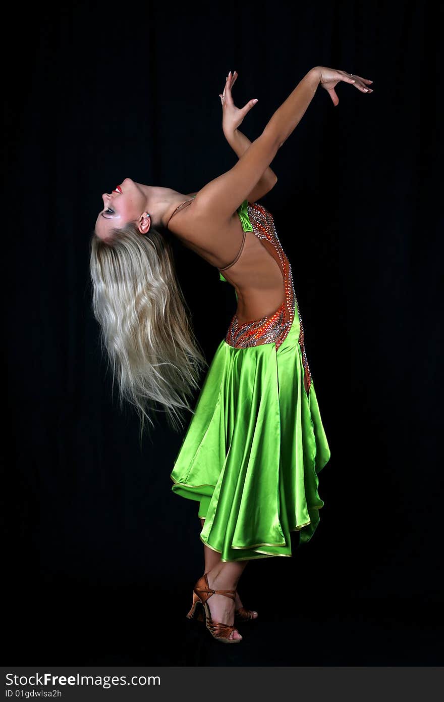 Lovely blondie girl latin dancer in green dress against black background. Lovely blondie girl latin dancer in green dress against black background