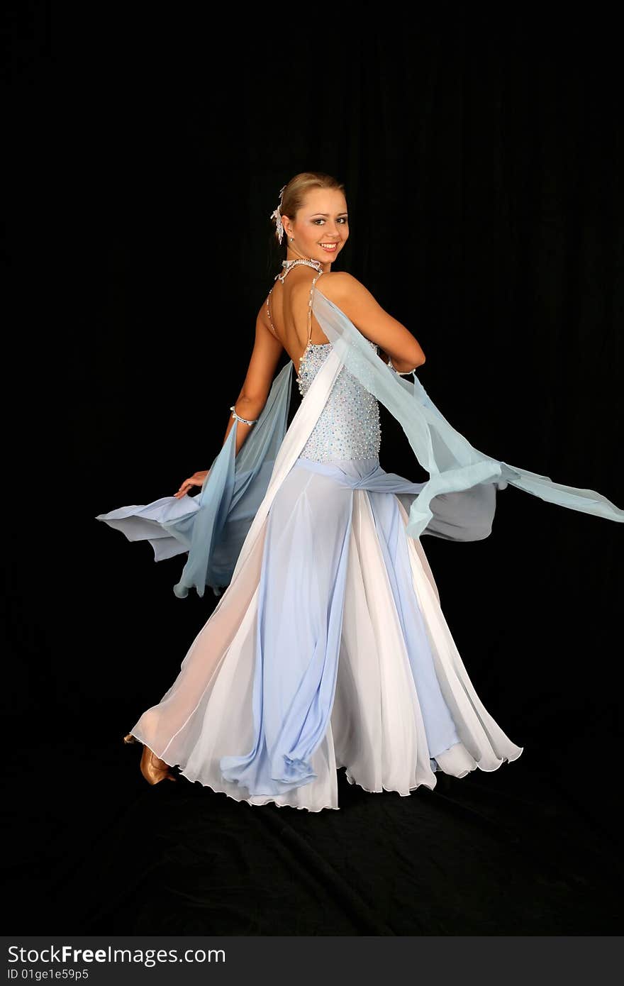 Dancer in classical blue-white dress against black background