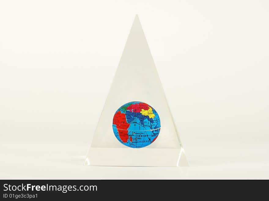 Color globe of the earth with visible countries and Indian Ocean inside a glass pyramid. Color globe of the earth with visible countries and Indian Ocean inside a glass pyramid