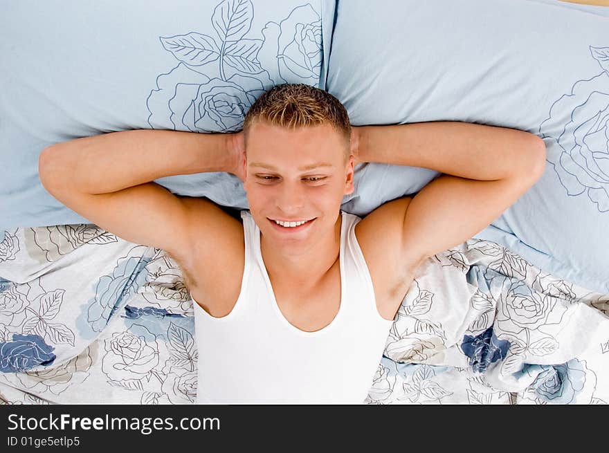 Tired young male relaxing on his bed in bed. Tired young male relaxing on his bed in bed