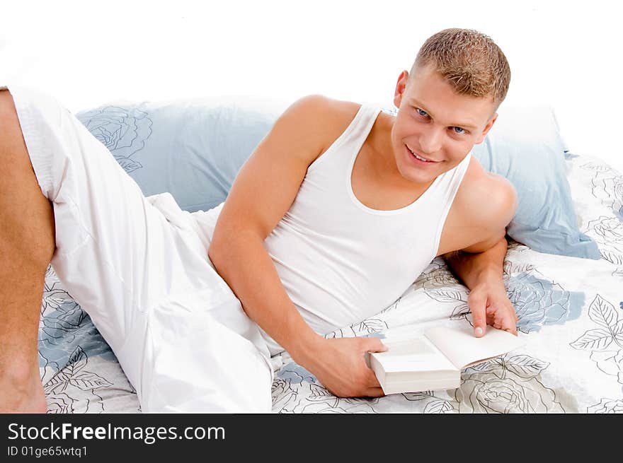 Young man reading book in bed