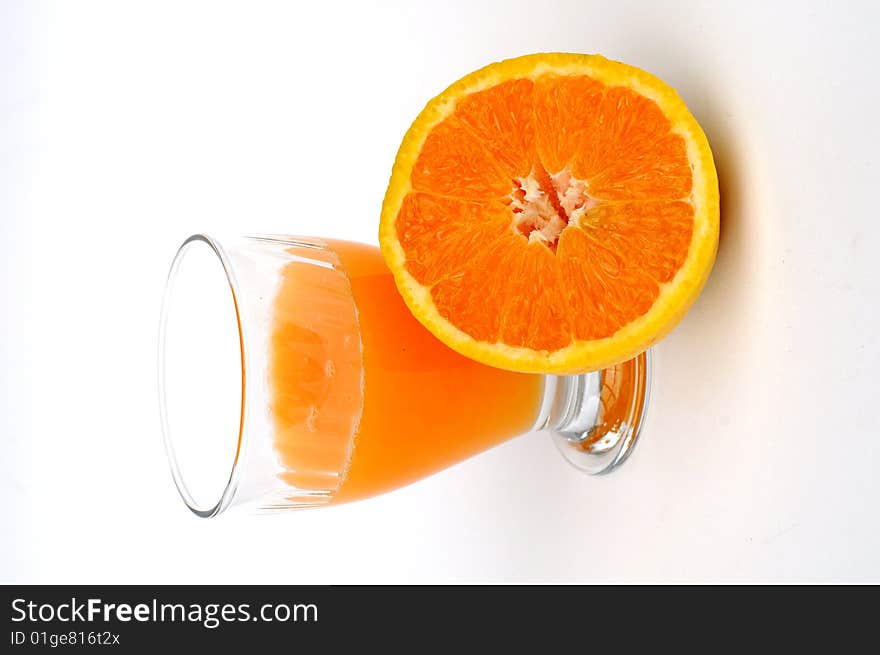 Cut Orange with with a half full glass of juice. Cut Orange with with a half full glass of juice