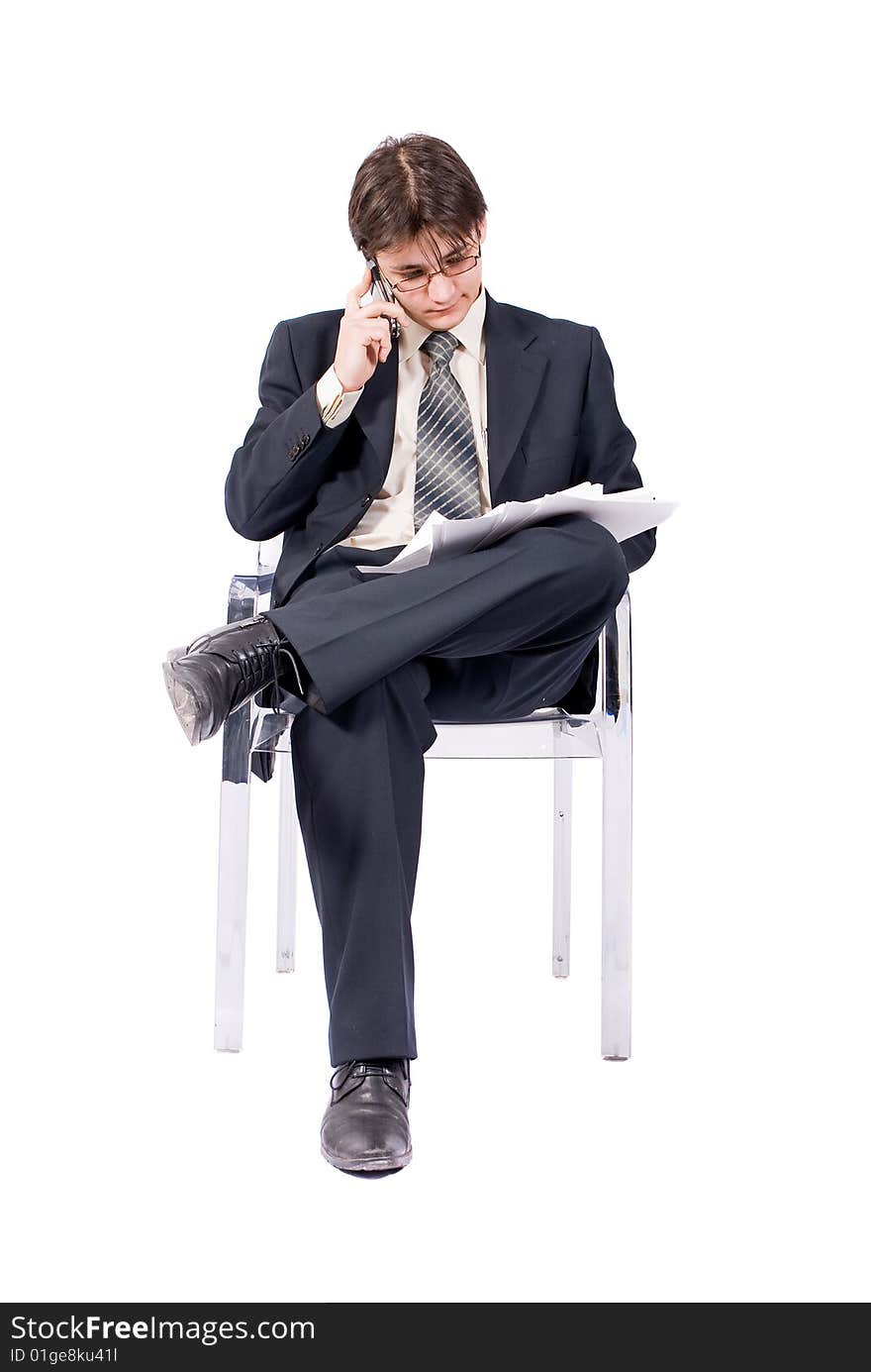 Young businessman looks documents and calling by cellular phone. Over white