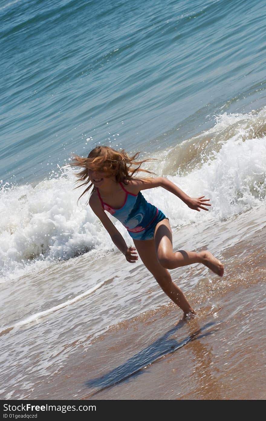 Happy little girl running on the beach