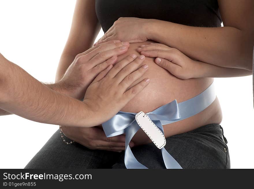 Family touching mom's belly with blue ribbon and tag