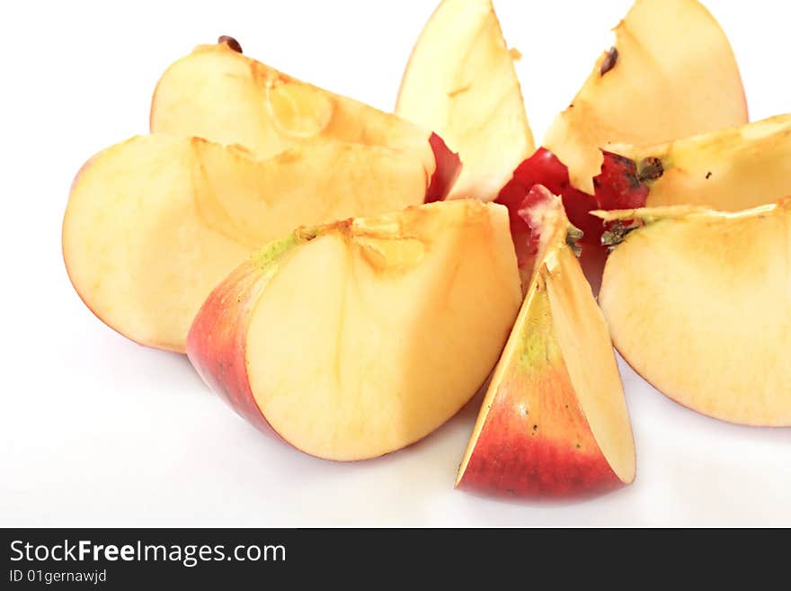 An apple is cut by lobules on a white background. An apple is cut by lobules on a white background.