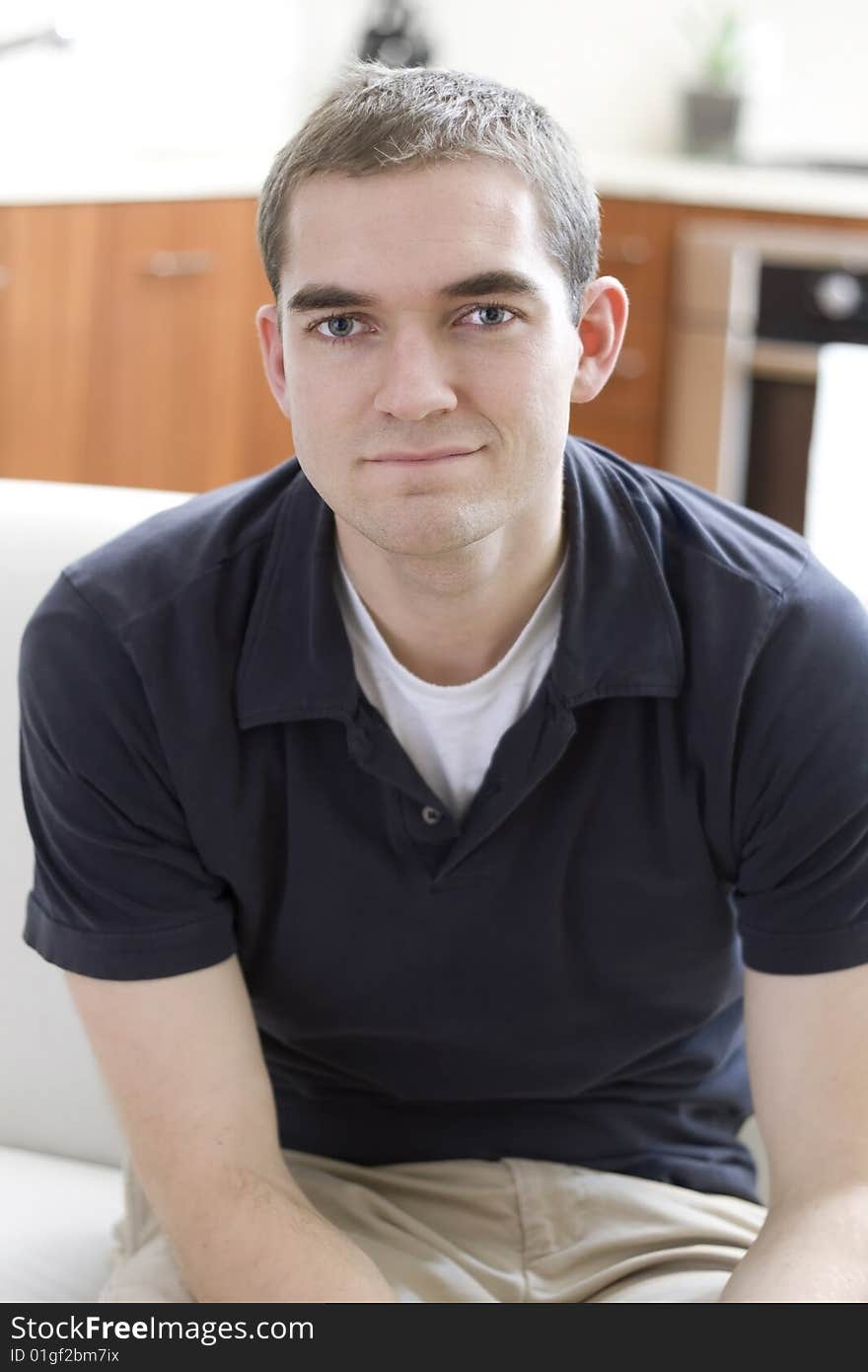 Handsome young adult relaxing in a modern home. Handsome young adult relaxing in a modern home.