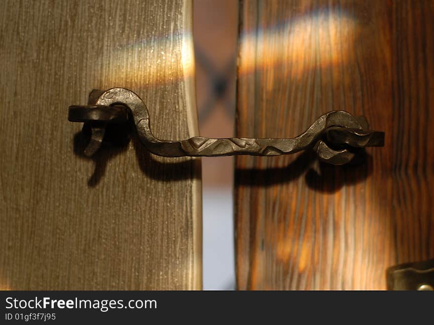 Metallic hook closes an old vintage wooden door. Metallic hook closes an old vintage wooden door