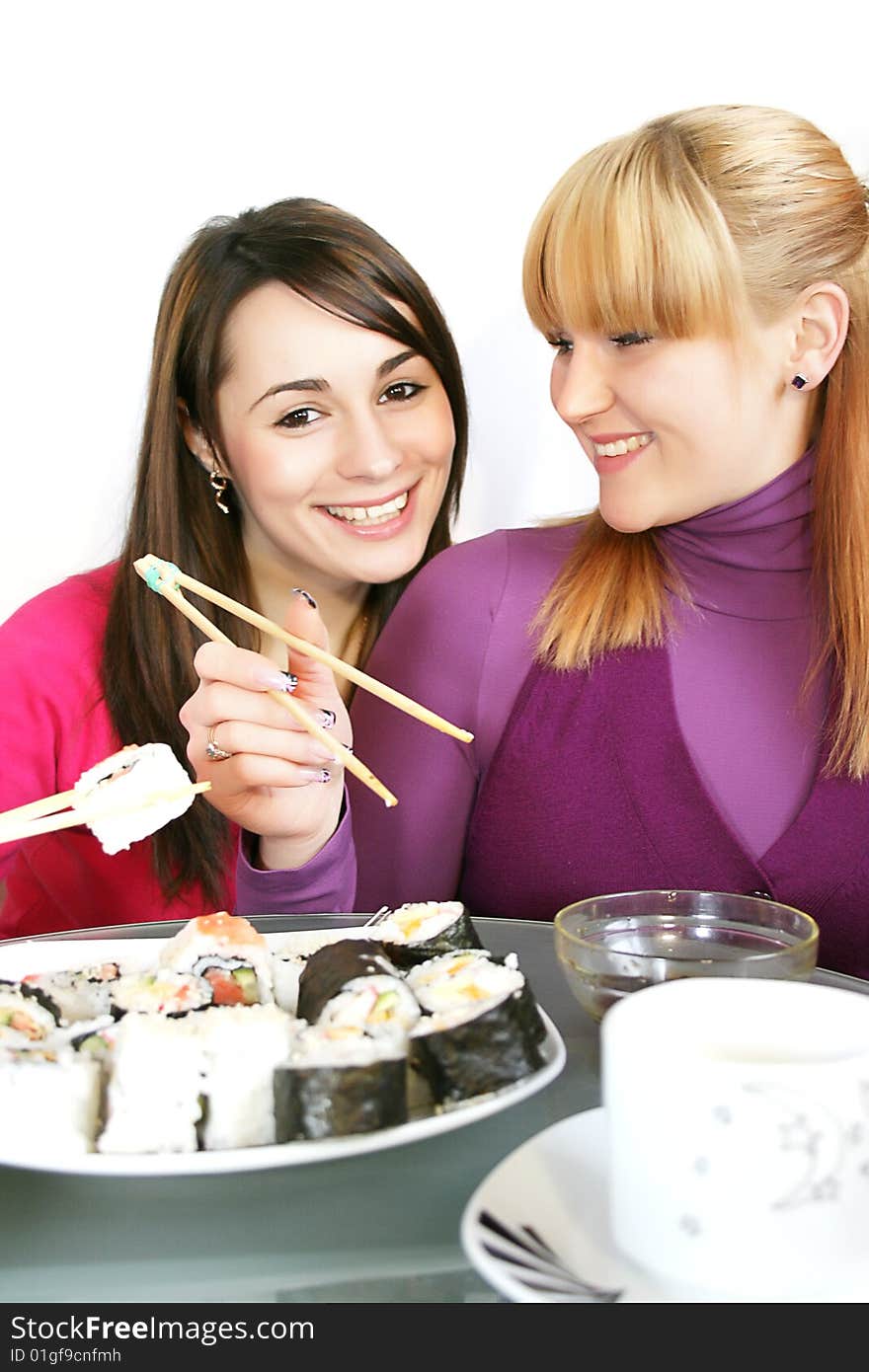 A pretty young  womans eating salmon sushi with chopsticks. A pretty young  womans eating salmon sushi with chopsticks