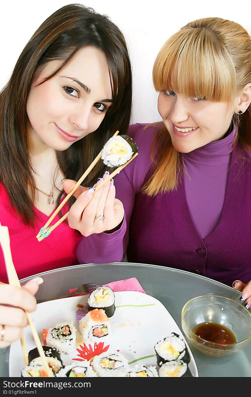 A pretty young  womans eating salmon sushi with chopsticks. A pretty young  womans eating salmon sushi with chopsticks