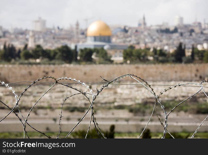 Jerusalem Old City with The Dome of the Rock. View from Olive Mountain over razor wire.