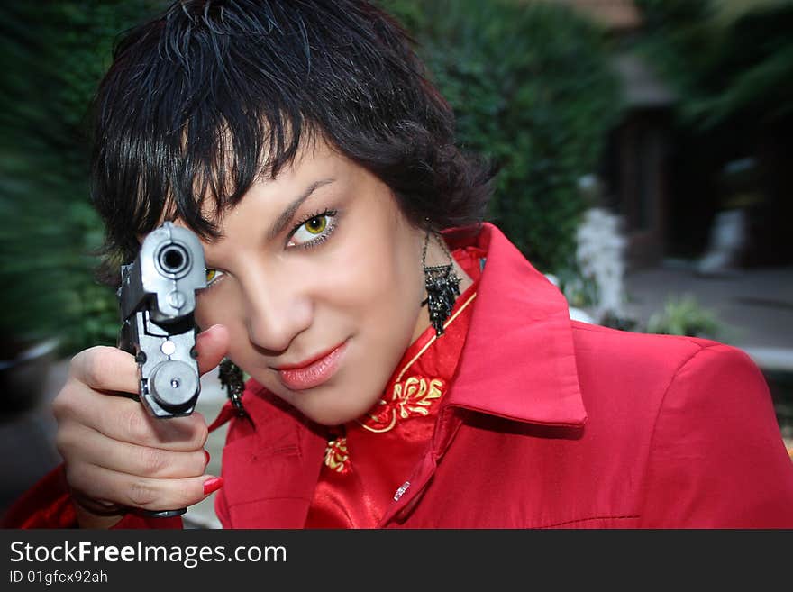 attractive brunette woman with gun aiming at camera on a dynamic background. attractive brunette woman with gun aiming at camera on a dynamic background