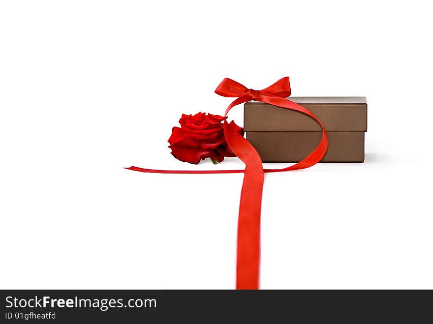 Gift box with red rose and ribbon over a white background