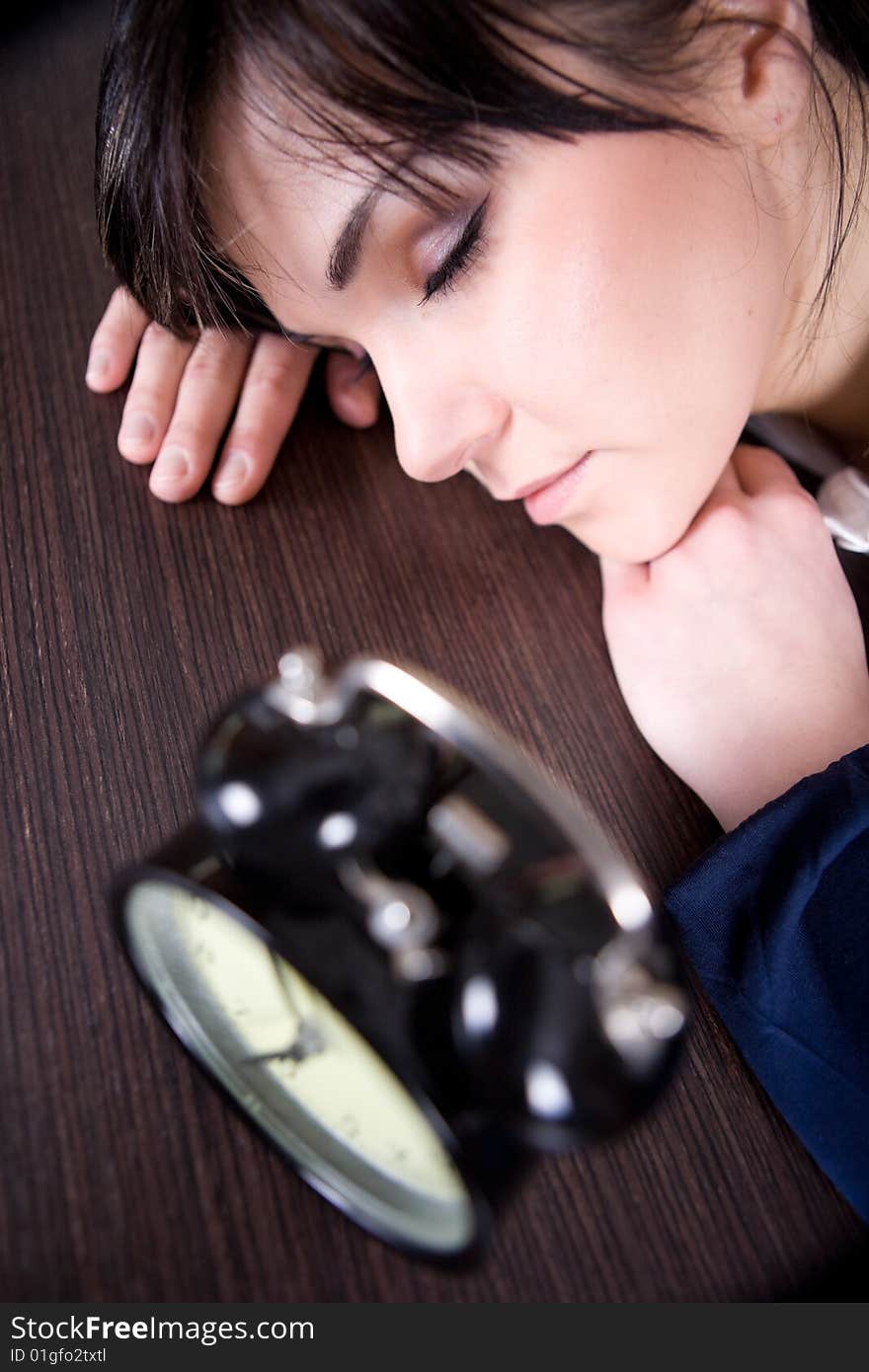 Attractive brunette and tired woman with clock