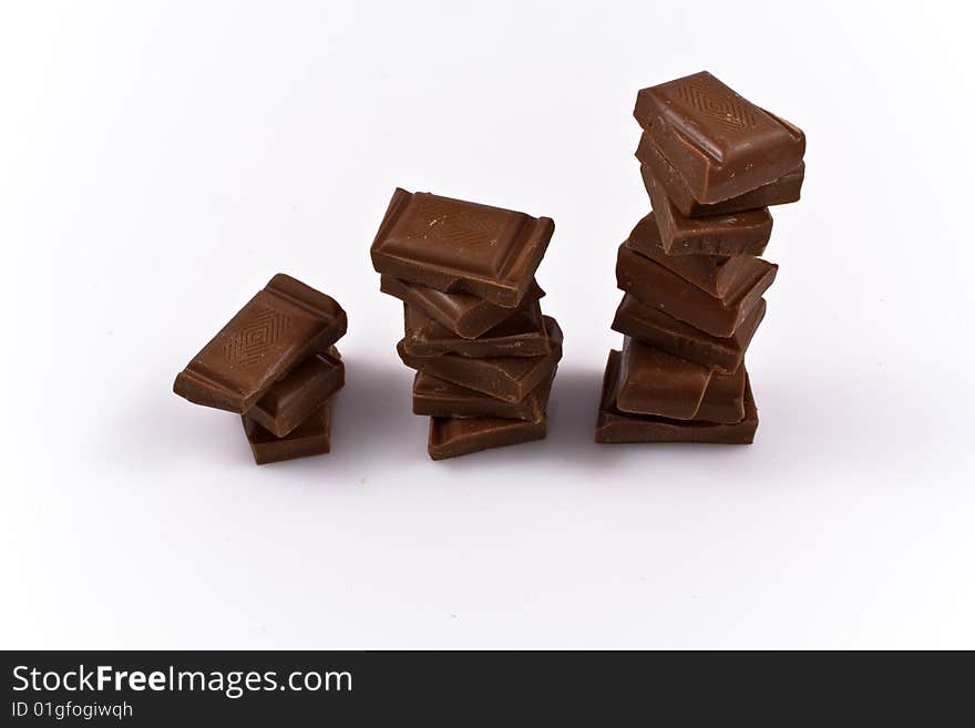 Stack of chocolate chunks isolated on white. Illustration of sweets consuption growth rate.