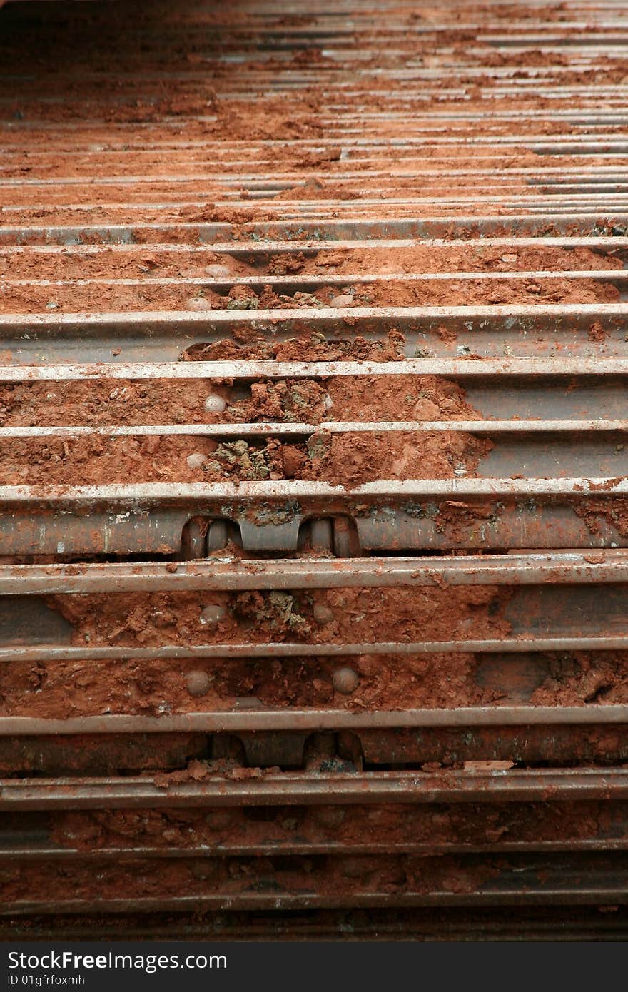 Muddy caterpillar tracks on a backhoe