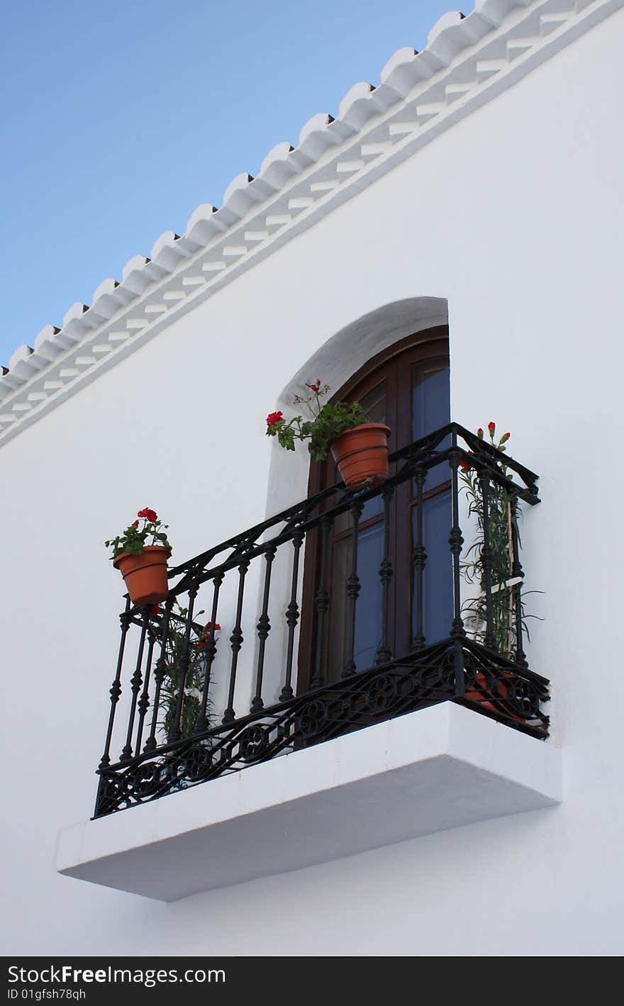 Ornate balcony with plants in the village of Frigiliana in Spain. Ornate balcony with plants in the village of Frigiliana in Spain.